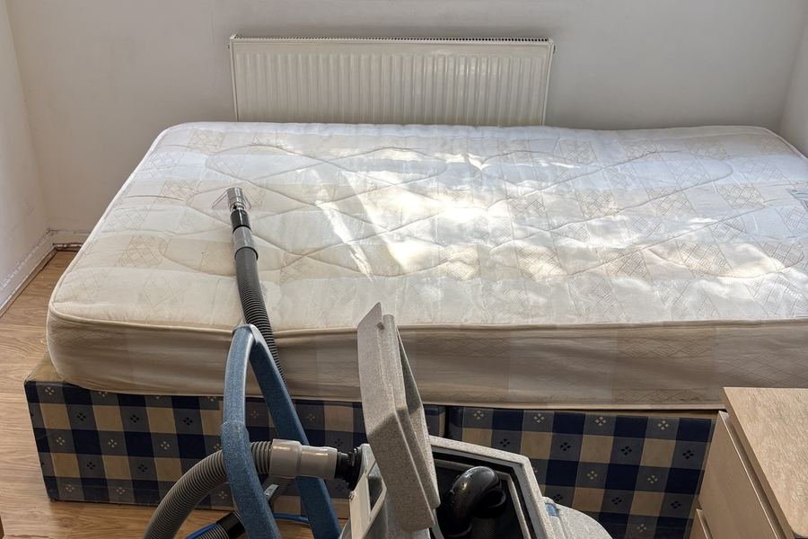 Mattress being cleaned with a Prochem upholstery tool in a bright bedroom
