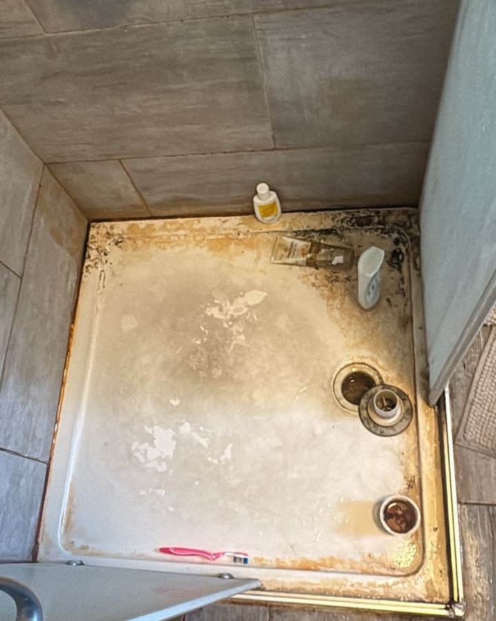 Shower tray before cleaning with heavy limescale, mould and staining around the edges