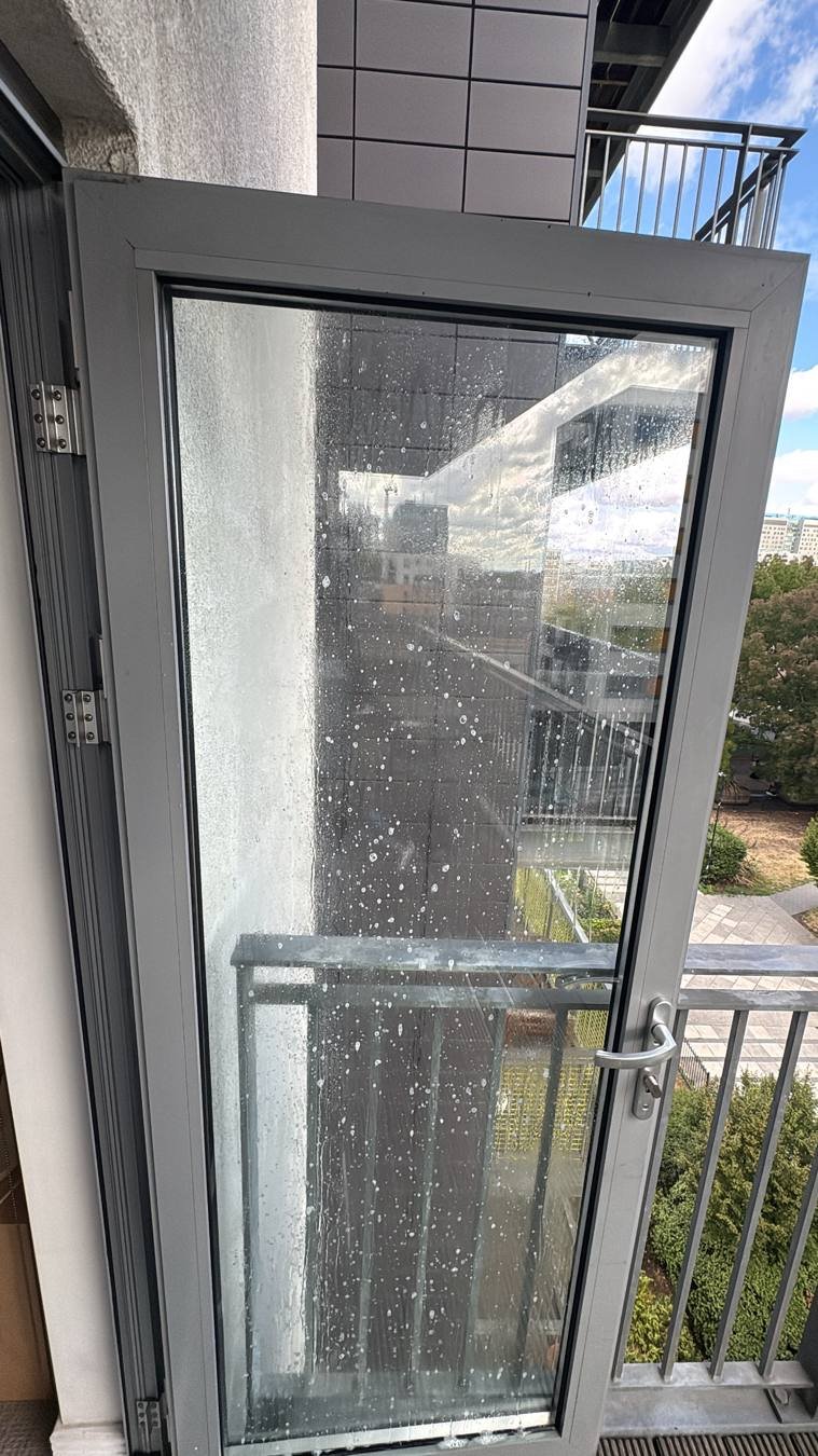 Balcony door glass being cleaned on a high-rise London flat